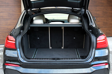 Car trunk. Rear view of the car open trunk. Sport SUV big trunk open. Modern SUV car have an open trunk. The car boot is open and ready for luggage loading. 