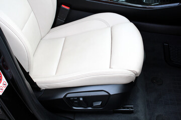 Obraz premium Light leather Driver seat of a new modern car. Beige Leather car interior. White leather drivers seat in a car. Front seats of a modern passenger car. 