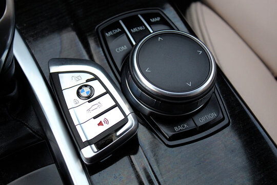 Vinnytsia, Ukraine; May 04, 2024. BMW X4 M Performance key. BMW Smart Key. BMW Car Key for Keyless start on dashboard. BMW idrive control panel of gearbox and multimedia drive selector.