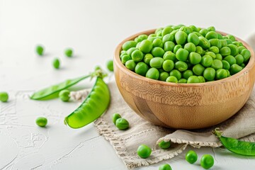 Organic green peas in wooden bowl with leaves on white background Healthy vegan food