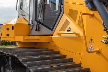 A modern bulldozer equipped with hydraulic attachments.