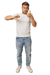 Full body portrait of a man in studio showing thumbs up and thumbs down, difficult choose concept