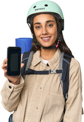 Young woman showcasing phone with hiking gear