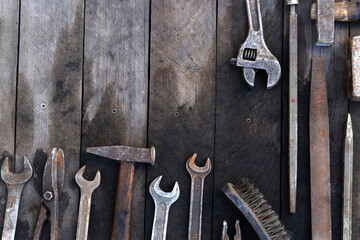 Old work tools on a wooden plank surface, top view. Hammers, sledgehammers, metal shears, pliers and more. Hand tool. Top view with copy space. Flat lay. Craftsmanship and handwork concept