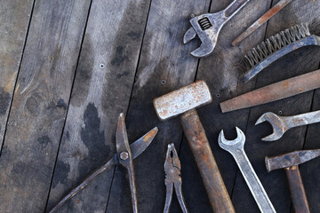 Old work tools on a wooden plank surface, top view. Hammers, sledgehammers, metal shears, pliers and more. Hand tool. Top view with copy space. Flat lay. Craftsmanship and handwork concept