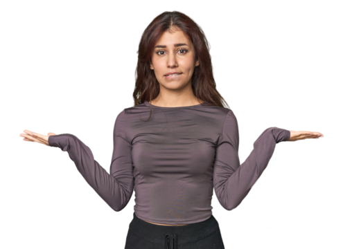 Middle Eastern woman in studio confused and doubtful shrugging shoulders to hold a copy space.