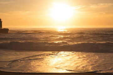 Naklejka premium Sunset in the ocean by the lighthouse