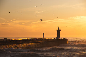 Sunset in the ocean by the lighthouse