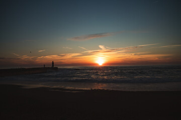 Sunset in the ocean by the lighthouse