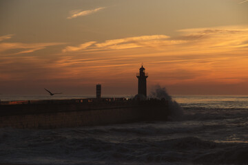 Sunset in the ocean by the lighthouse