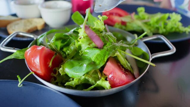 Fresh Green Salad with Tomatoes and Red Onions. Close-Up of a Person Serving a Healthy Salad with Fresh Vegetables
