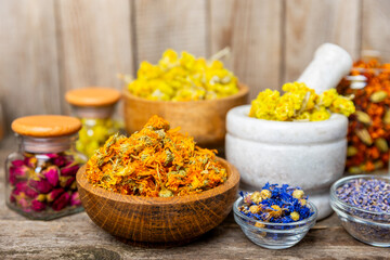 Assortment of dry herbal and berry tea on a wooden background. Tea party concept. medicinal herbs. Healing herbs.Alternative medicine.Linden, calendula, cornflowers, marigold, tansy, tea rose.