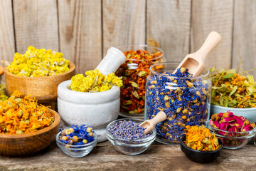 Assortment of dry herbal and berry tea on a wooden background. Tea party concept. medicinal herbs. Healing herbs.Alternative medicine.Linden, calendula, cornflowers, marigold, tansy, tea rose.