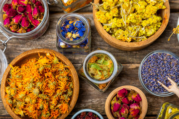 Assortment of dry herbal and berry tea on a wooden background. Tea party concept. medicinal herbs. Healing herbs.Alternative medicine.Linden, calendula, cornflowers, marigold, tansy, tea rose.