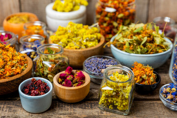 Assortment of dry herbal and berry tea on a wooden background. Tea party concept. medicinal herbs. Healing herbs.Alternative medicine.Linden, calendula, cornflowers, marigold, tansy, tea rose.