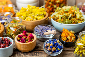 Assortment of dry herbal and berry tea on a wooden background. Tea party concept. medicinal herbs. Healing herbs.Alternative medicine.Linden, calendula, cornflowers, marigold, tansy, tea rose.