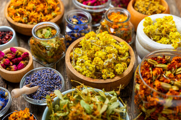 Assortment of dry herbal and berry tea on a wooden background. Tea party concept. medicinal herbs. Healing herbs.Alternative medicine.Linden, calendula, cornflowers, marigold, tansy, tea rose.