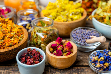 Assortment of dry herbal and berry tea on a wooden background. Tea party concept. medicinal herbs. Healing herbs.Alternative medicine.Linden, calendula, cornflowers, marigold, tansy, tea rose.
