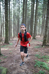 A guy is running in the forest.