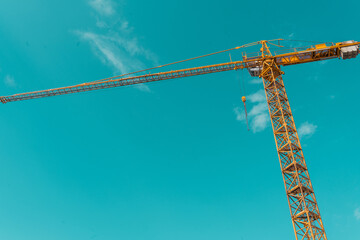 Yellow crane against blue skies. Building site concept.