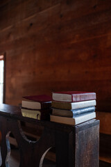 Stack of books laying on a shelf in an old church or schoolhouse 