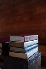 Stack of books laying on a shelf in an old church or schoolhouse