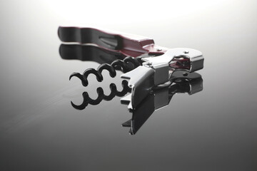 One corkscrew (sommelier knife) on mirror surface, closeup