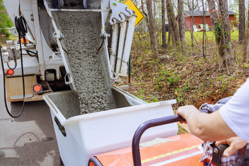 During when pouring concrete, workers use dumper tracked wheelbarrow in construction site