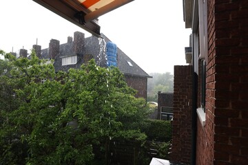 View of green trees and buildings on rainy day