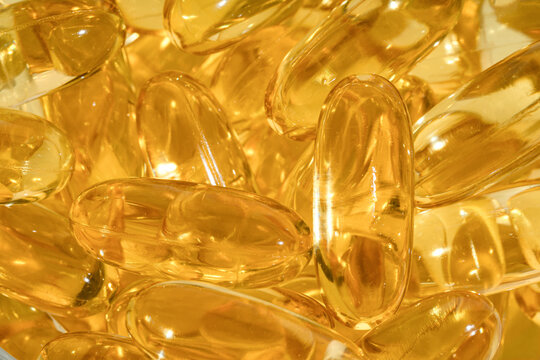Close-up view of shiny omega 3 capsules in a pile