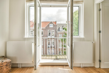 Bright room with an open balcony door and city view