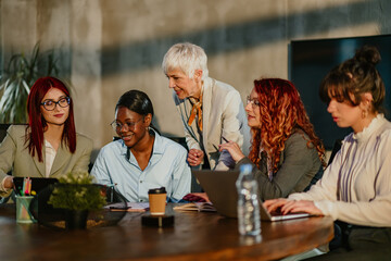 Interracial female businesswomen working on startup project with mentor