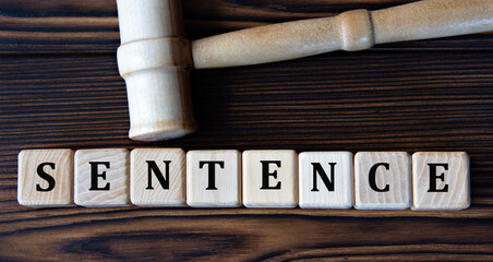 SENTENCE - word on wooden cubes on background of judge's gavel