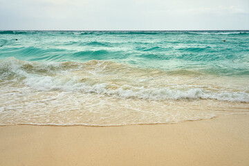 Waves and foam on a tropical sandy beach.