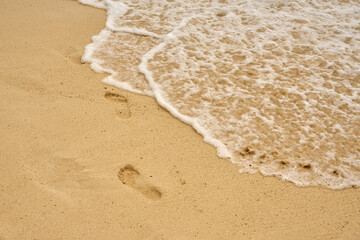Waves and foam on a tropical sandy beach.