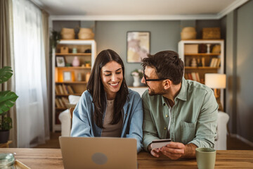 Boyfriend and girlfriend buy online on laptop with credit card at home