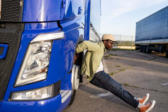 Professional driver using truck to stretch his body after long ride.
