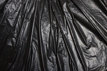 Abstract black wrinkled silk plastic texture background 