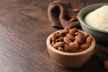 Fresh nuts and almond flour on wooden table, closeup. Space for text