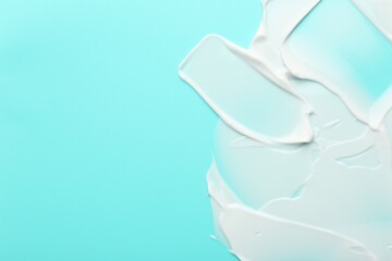Face cream on light blue background, top view. Space for text