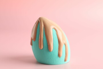 Makeup sponge with skin foundation on pink background