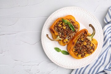 Quinoa stuffed peppers with corn and basil on white textured table, top view. Space for text