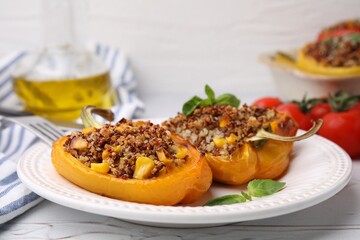 Quinoa stuffed peppers with corn and basil on white textured table