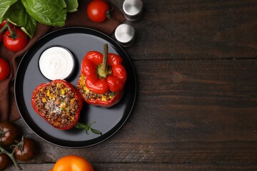 Quinoa stuffed peppers with corn on wooden table, flat lay. Space for text