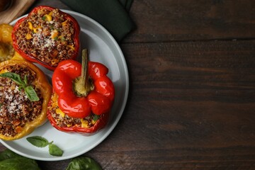 Quinoa stuffed peppers with corn and basil on wooden table, top view. Space for text
