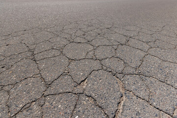 a part of a highway covered with cracked asphalt
