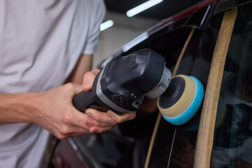 Car detailing enhances shine of vehicle with machine buffer for glossy finish