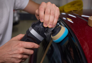 Car detailing enhances shine of vehicle with machine buffer for glossy finish