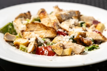 Caesar Salad, Green Lettuce Salat with Chicken and Parmesan Cheese Closeup