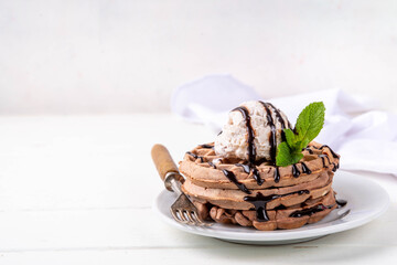 Stack of chocolate waffles with ice cream and topping